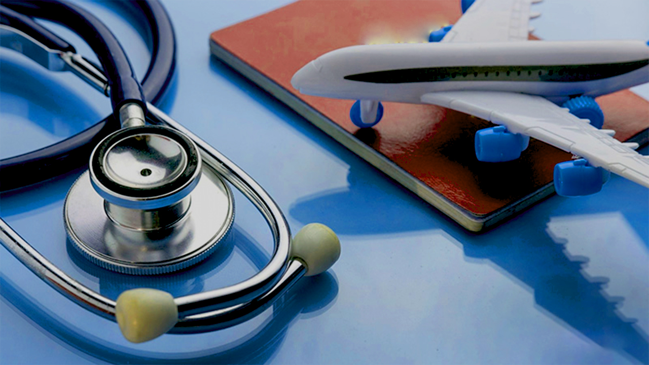 Stethoscope and a model aeroplane resting on a passport